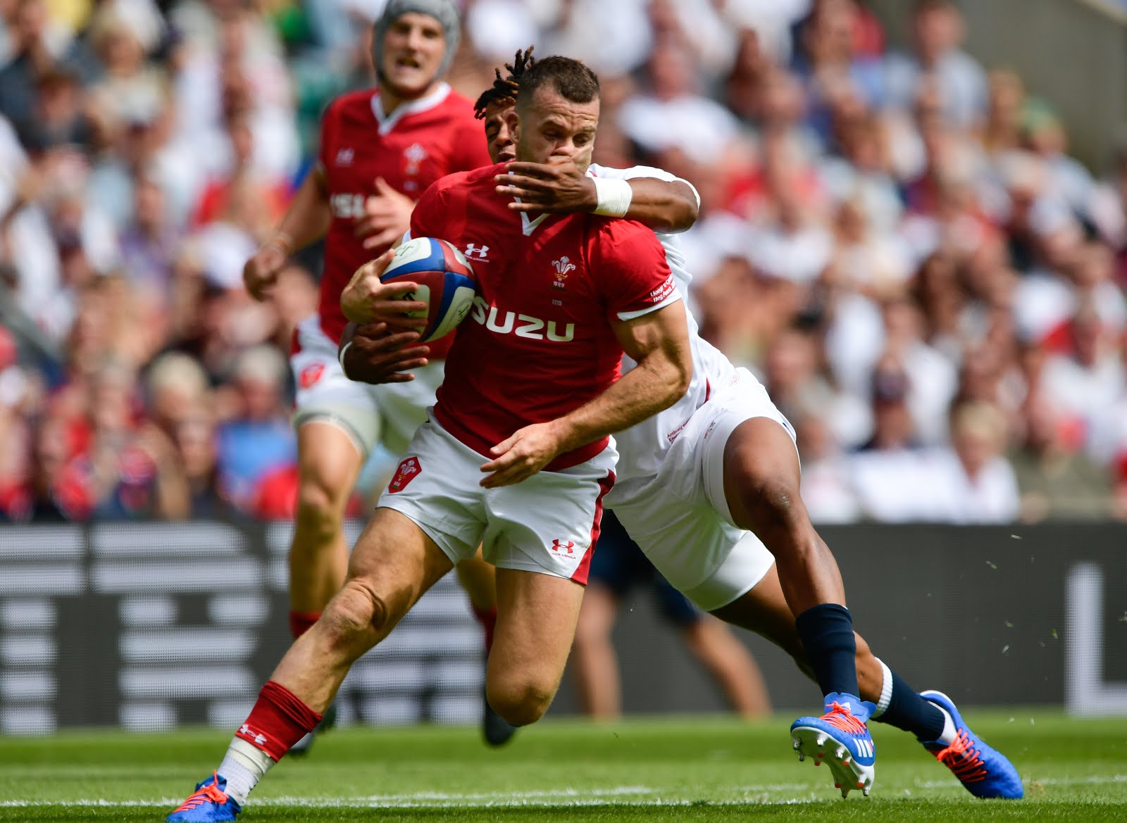 Anthony Watson of England makes a tackle on Gareth Davies of Wales 