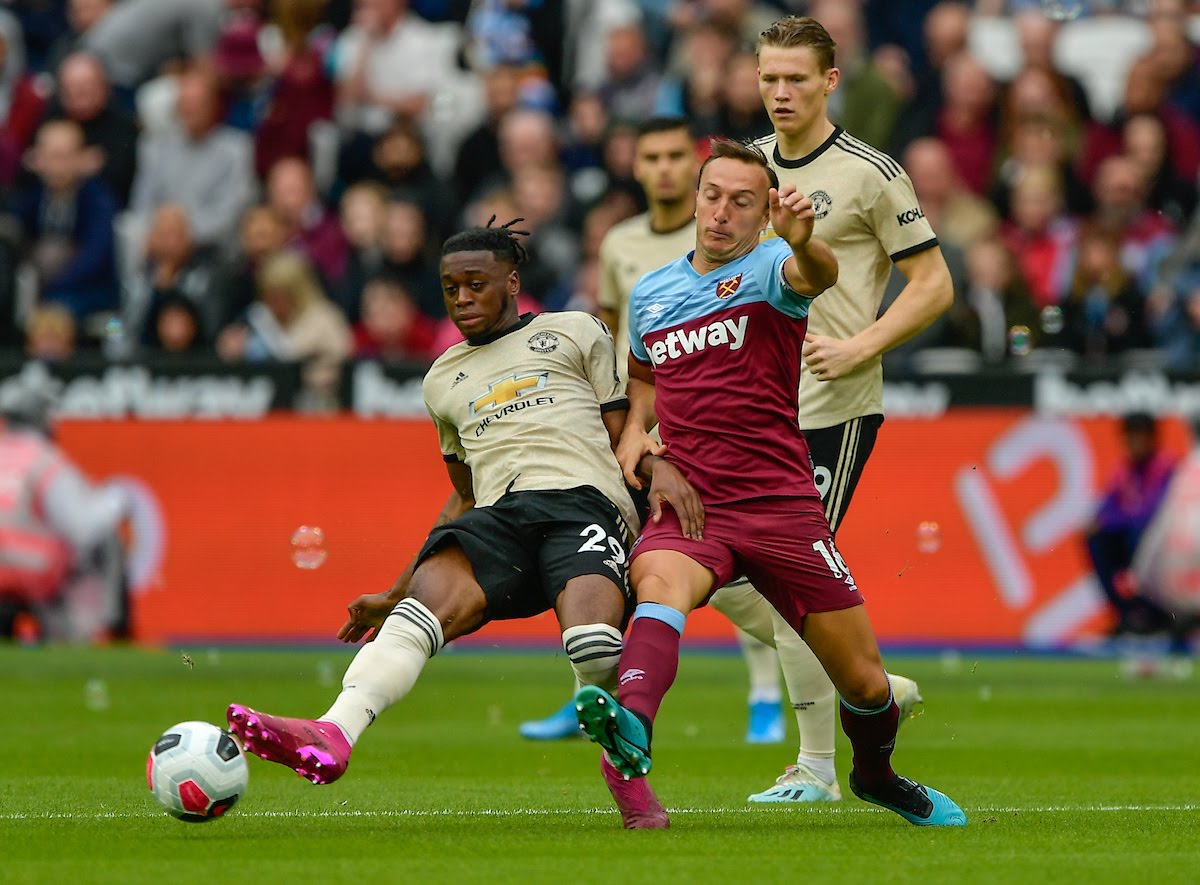 Mark Noble of West Ham United battles for the ball with Aaron Wan-Bissaka of Manchester United