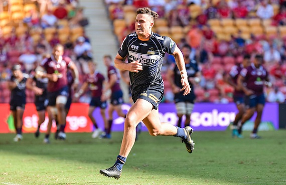 Tom Banks of the Brumbies chases a kick against the Reds
