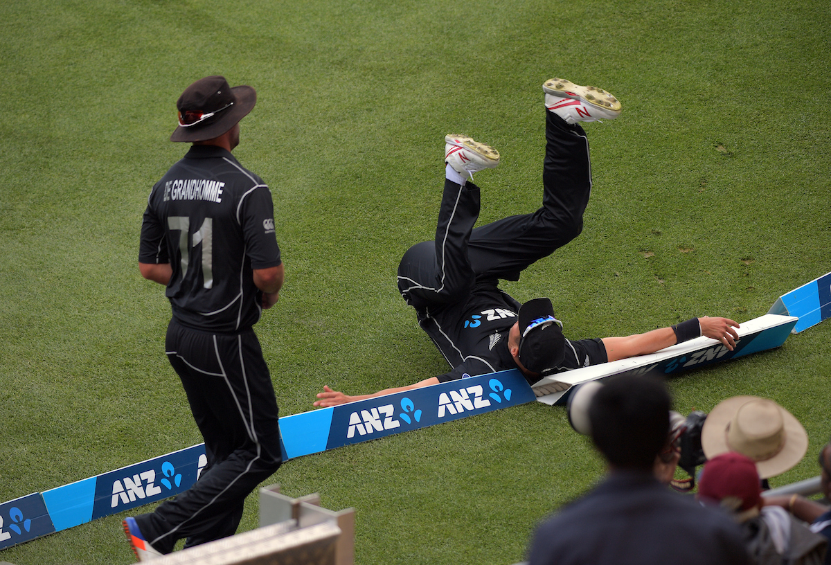 Trent Boult falls over the boundary ropes
