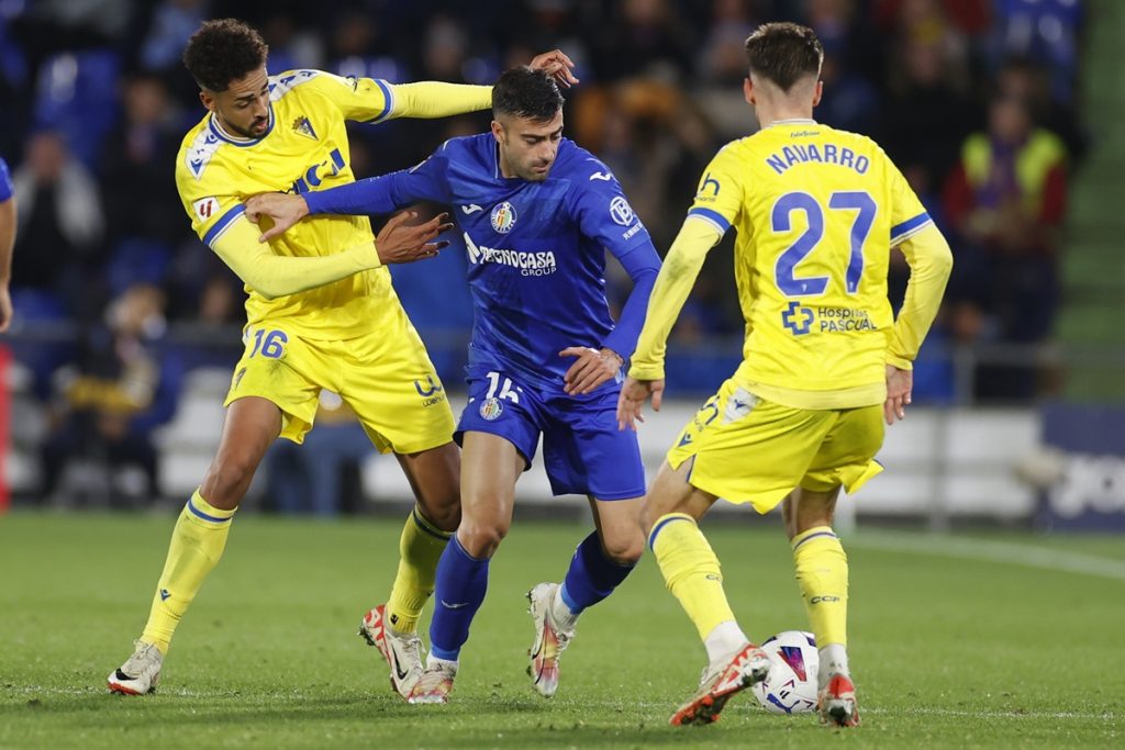 Getafe's defender Diego Rico (C) in action against Cadiz's striker Chris Ramos (L) and midfielder Robert Navarro (R)
