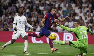 Real Madrid's goalkeeper Lunin (R) in action against FC Barcelona's Spanish striker Ferran Torres (C) during the LaLiga soccer match between Real Madrid and FC Barcelona, at the Santiago Bernabeu Stadium.