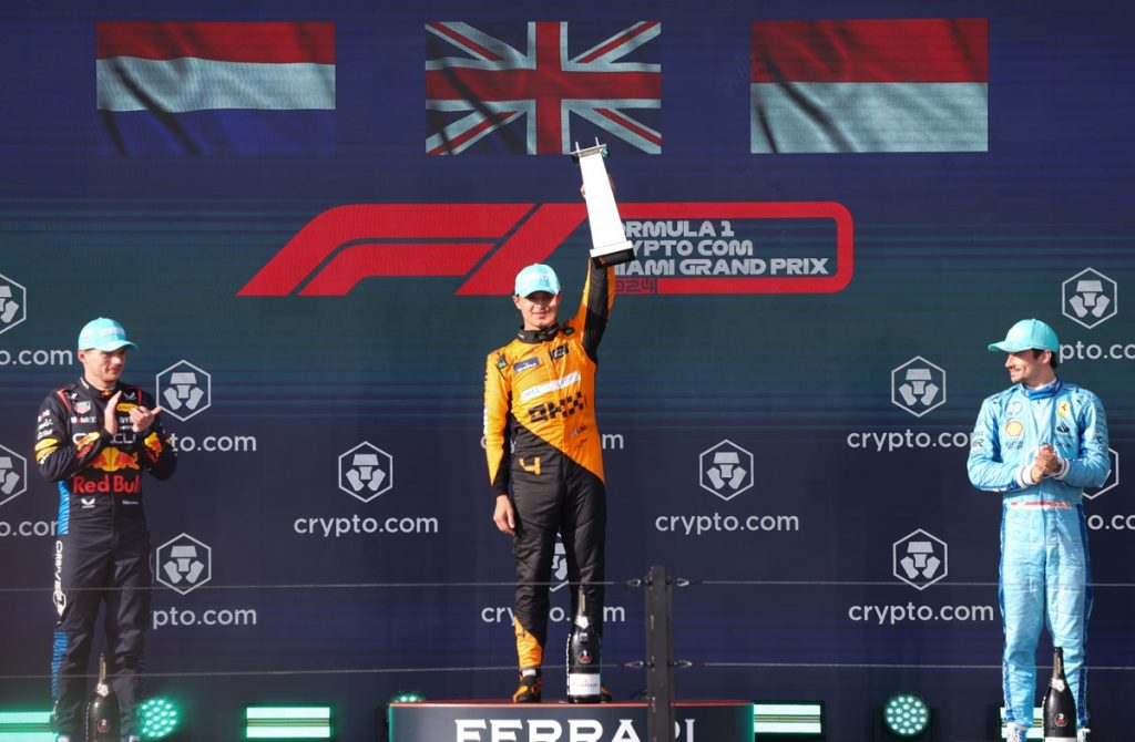 First place McLaren driver Lando Norris of Britain (C) holds up his trophy as second place Red Bull Racing driver Max Verstappen of Netherlands (L) and Scuderia Ferrari driver Charles Leclerc of Monaco (R) applaud on the winners podium in the Formula 1 Miami Grand Prix, at the Miami International Autodrome.