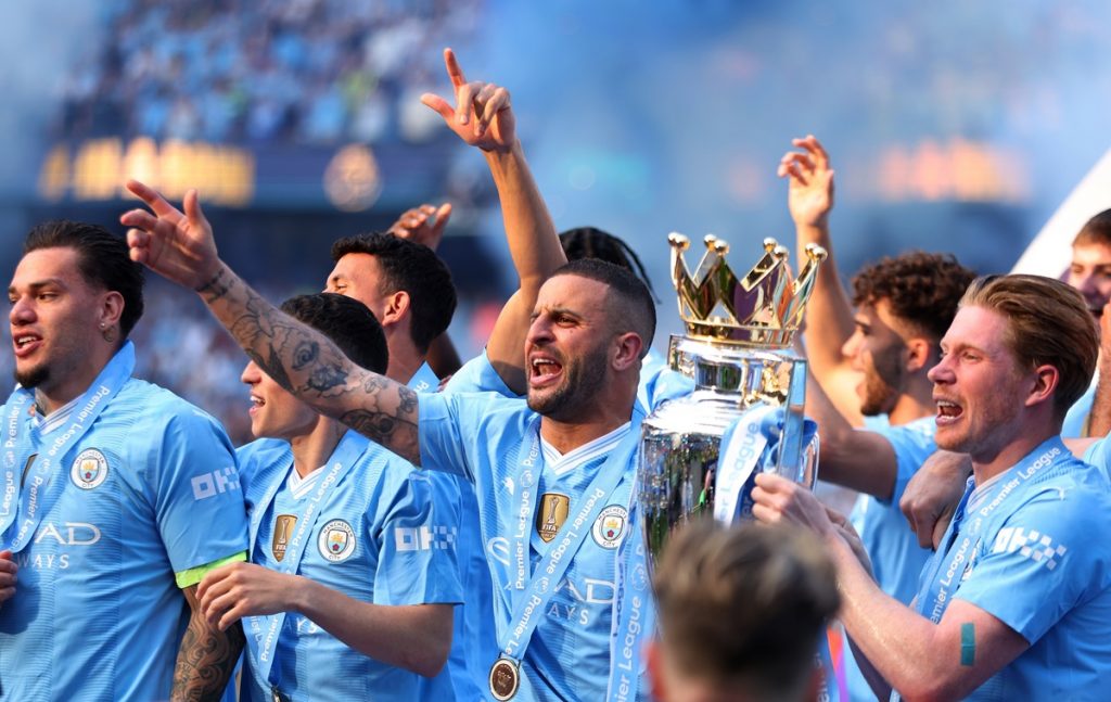 Manchester City's players celebrate as captain Kyle Walker (C) lifts the Premier League championship trophy, the fourth consecutive won by City, after the English Premier League soccer match of Manchester City against West Ham United, in Manchester.