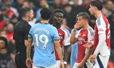 epa11619556 Referee Michael Oliver (L) shows a red card to Arsenal's Leandro Trossard (2-R) during the English Premier League match between Manchester City and Arsenal in Manchester, Britain, 22 September 2024.